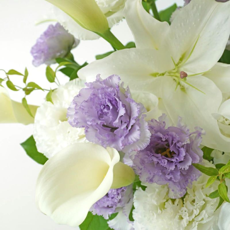 白い大輪ユリ・カサブランカと白と淡い紫のトルコキキョウなどのお供えアレンジメント