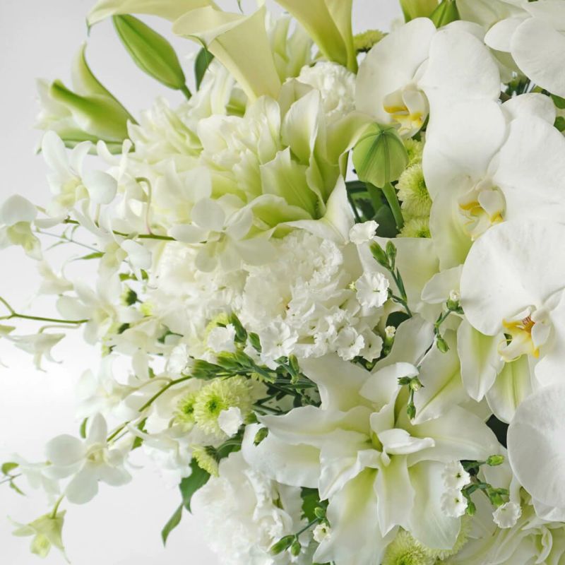 大輪胡蝶蘭や八重咲きユリなど純白のお供えアレンジメント